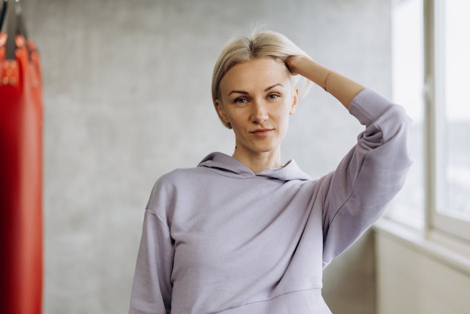 Woman demonstrating a strong warrior yoga pose in a minimalist setting